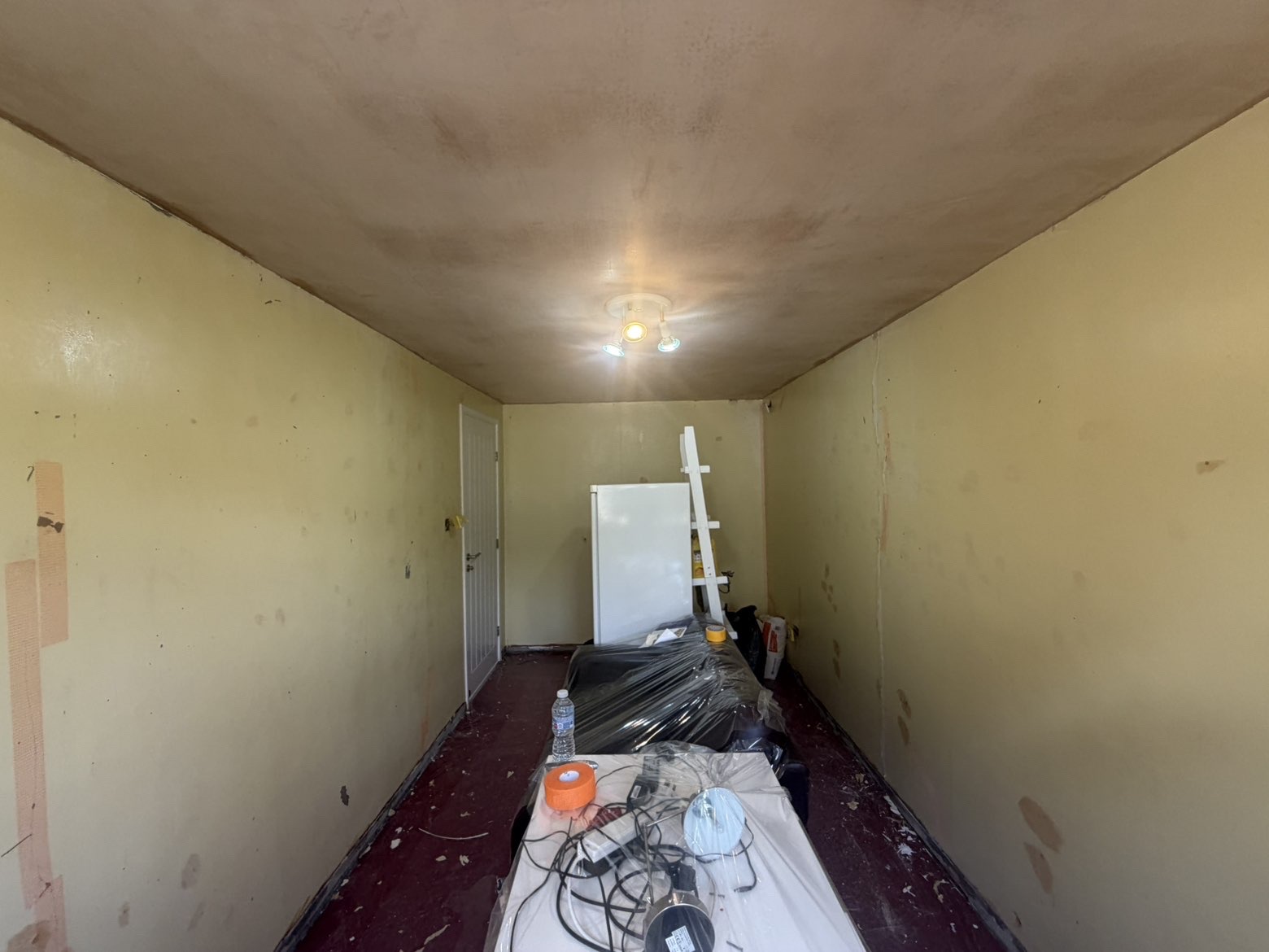 Same room mid-job — ceiling skimmed before walls were tackled